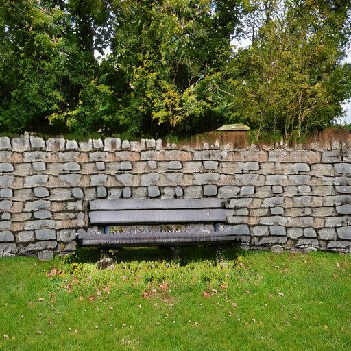 A photograph of a memorial bench which has been generated using artificial intelligence.
