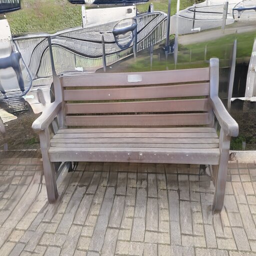 A photograph of a memorial bench which has been generated using artificial intelligence.