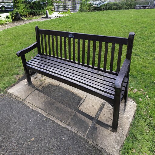 A photograph of a memorial bench which has been generated using artificial intelligence.