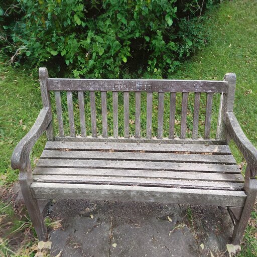 A photograph of a memorial bench which has been generated using artificial intelligence.