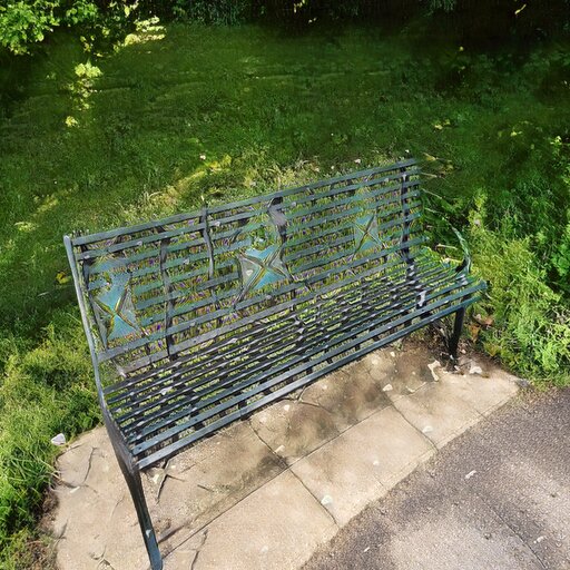 A photograph of a memorial bench which has been generated using artificial intelligence.