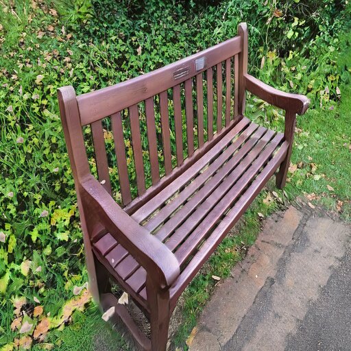 A photograph of a memorial bench which has been generated using artificial intelligence.