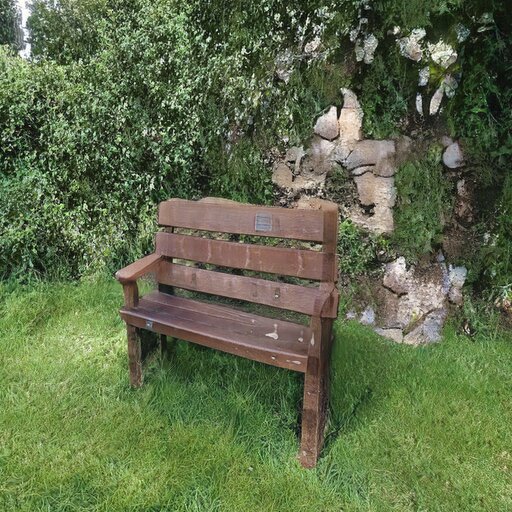 A photograph of a memorial bench which has been generated using artificial intelligence.