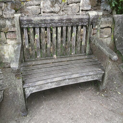 A photograph of a memorial bench which has been generated using artificial intelligence.