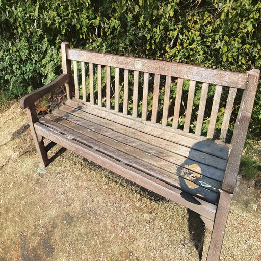 A photograph of a memorial bench which has been generated using artificial intelligence.